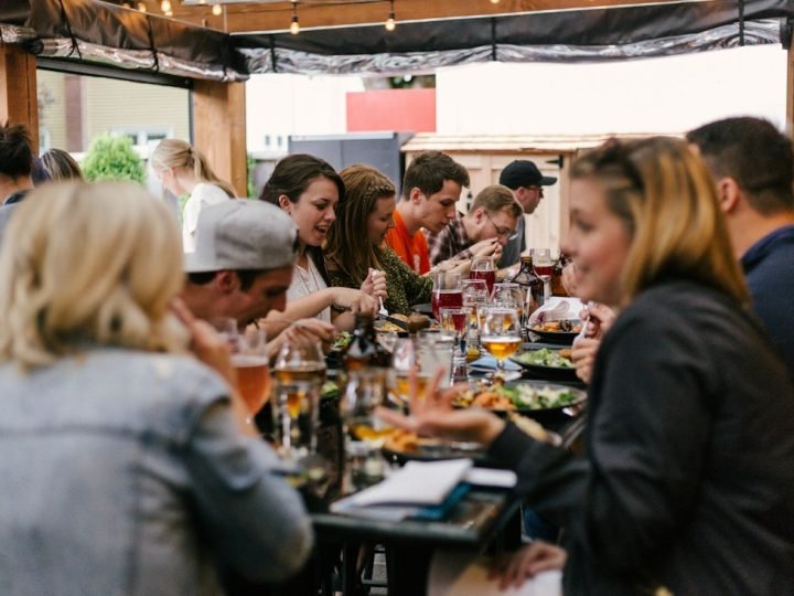 Long-table dinner with friends talking and eating