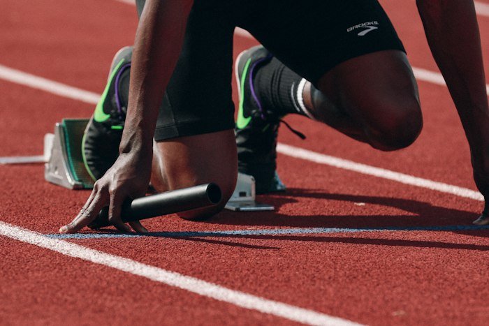 Runner in starting blocks on a red running track