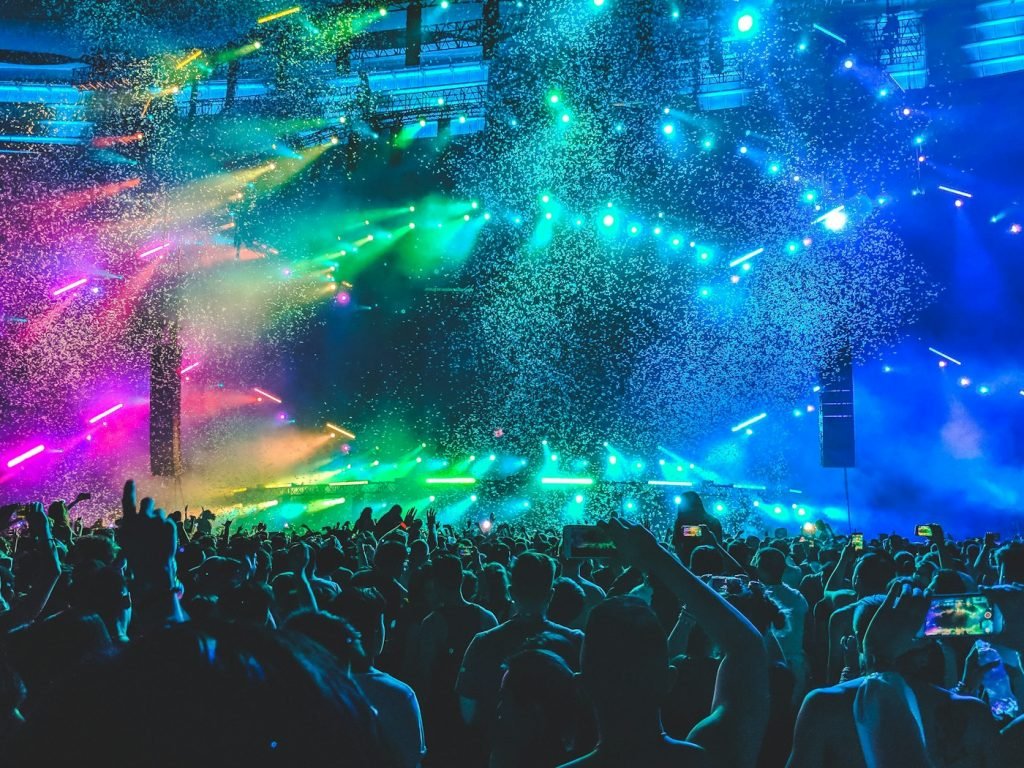 Crowd at a festival under bright neon lights and confetti