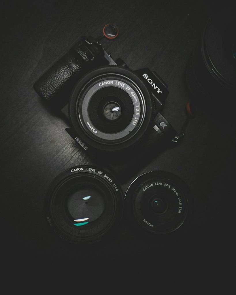 Camera and lenses laid out on a dark table