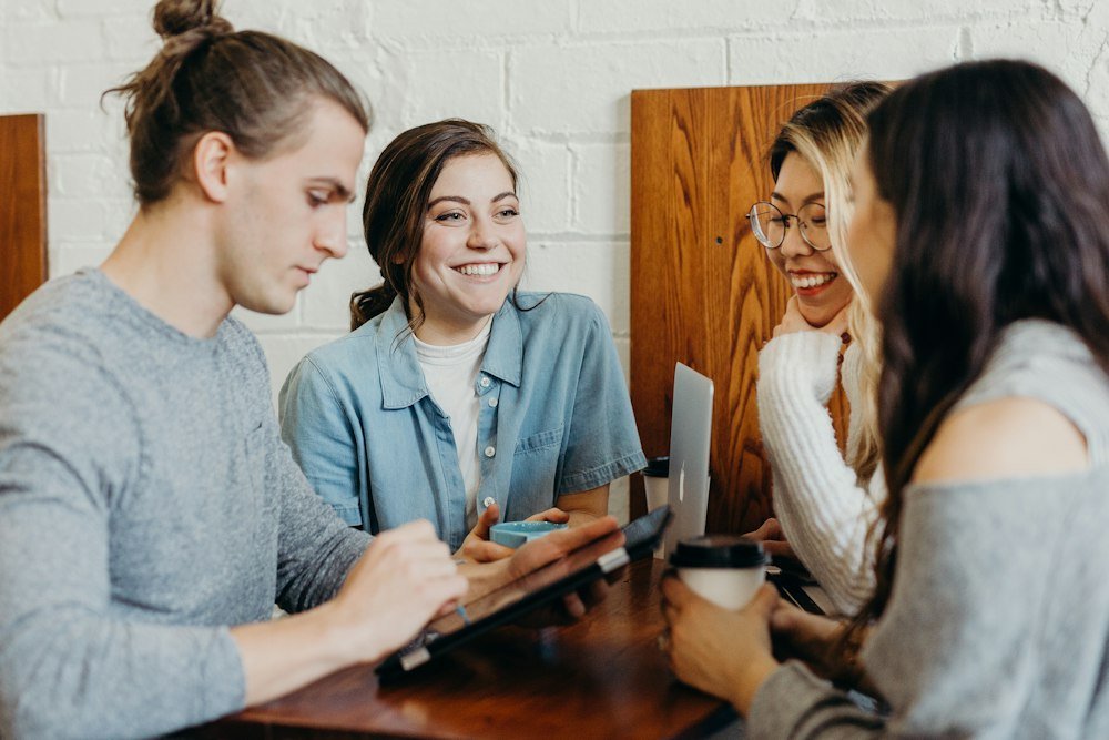 Friends chatting and laughing around a cafe table